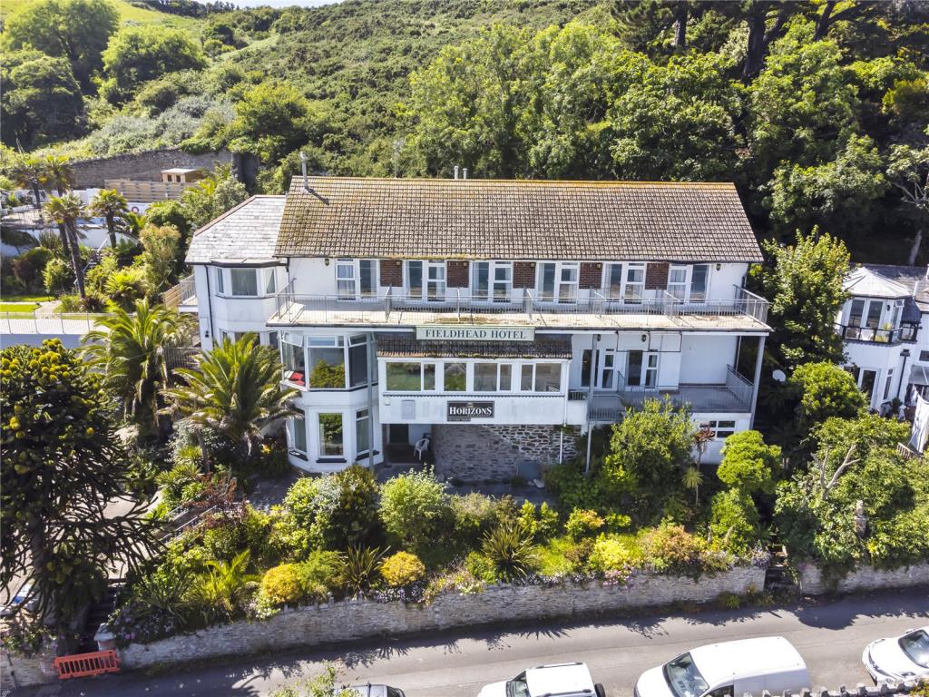 Lot: 80 - FORMER HOTEL WITH EXTENSIVE SEA VIEWS AND PLANNING FOR CONVERSION INTO FOUR HOUSES - Aerial photo showing front elevation of property